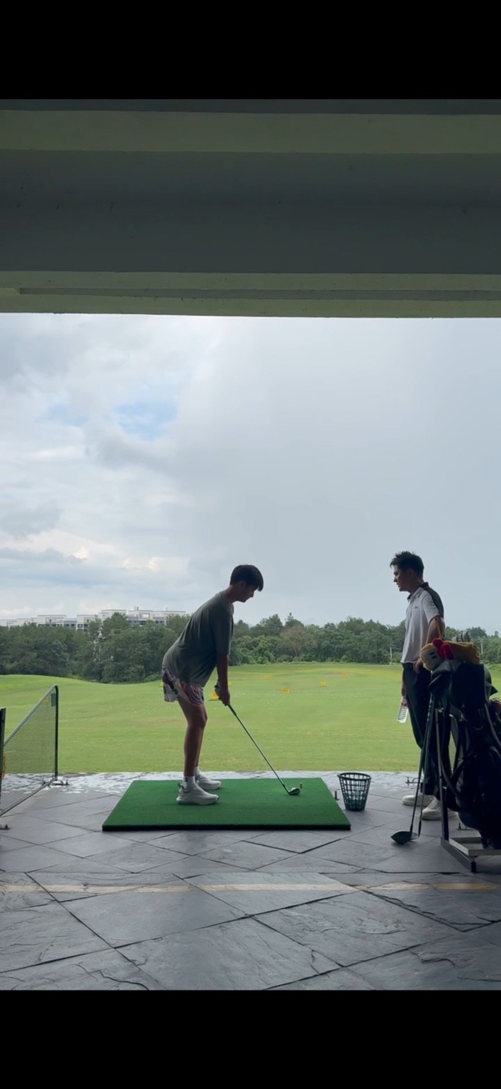 Tianqi practising with assistant coach Yang Chao at the driving range